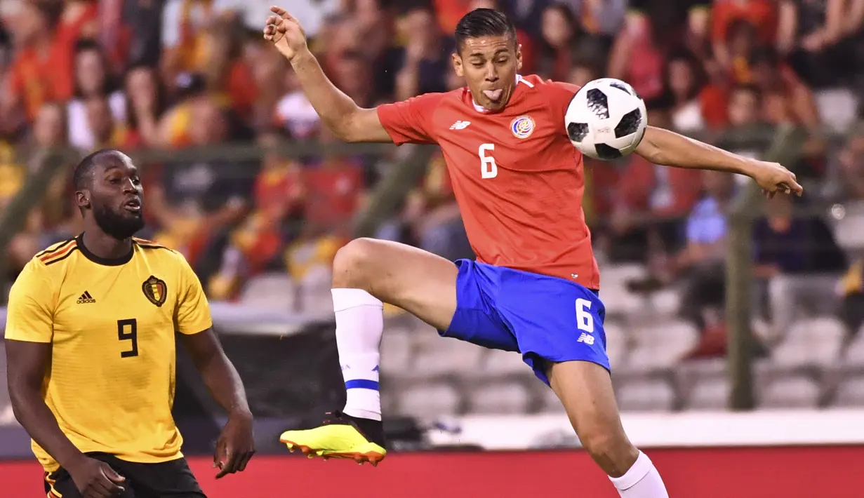 Pemain Kosta Rika, Oscar Duarte mengontrol bola dari kejaran pemain Belgia, Romelu Lukaku pada laga uji coba di King Baudouin stadium, Brussels, (11/6/2018). Belgia menang 4-1. (AP/Geert Vanden Wijngaert)