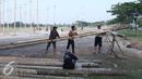 Pekerja mempersiapkan pohon pinang di Pantai Karnaval Ancol, Jakarta, Jumat (12/8). Taman Impian Jaya Ancol menyiapkan lomba panjat pinang kolosal dengan total pohon pinang mencapai 171 pohon. (Liputan6.com/Herman Zakharia)