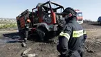 Petugas menyemprotkan air ke mobil pemadam kebakaran yang dilalap api di dekat Kalyvia, Yunani, Kamis (3/8). Tiga petugas pemadam kebakaran cedera ketika berusaha memadamkan kebakaran besar yang melanda lahan di selatan Athena. (AP/Thanassis Stavrakis)