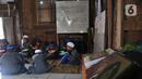 Santri saat makan bersama di depan Pondok Pesantren Jamhariyah, Dusun Grogolan, Sleman, Yogyakarta, Senin (28/3/2022). Didirikan pada 2019 oleh Ustaz Randy yang terinspirasi dari perjalanannya ke negara Asia Selatan seperti India, Bangladesh, dan Pakistan. (merdeka.com/Iqbal S Nugroho)