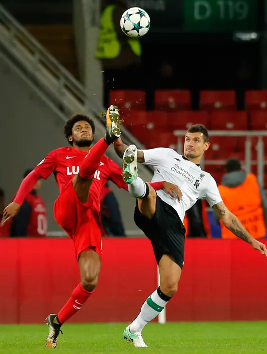 Pemain Spartak Moskow, Luiz Adriano dan pemain Liverpool, Dejan Lovren berebut bola dalam matchday 2 Grup E Liga Champions di Otkrytiye Arena, Rabu (27/9). Liverpool harus puas bermain imbang 1-1 di kandang Spartak Moskow. (AP/Alexander Zemlianichenko)