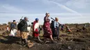 Sekelompok wanita pergi setelah menghabiskan malam menggali untuk mencari apa yang mereka yakini sebagai berlian setelah penemuan batu tak dikenal di desa KwaHlathi dekat Ladysmith, Afrika Selatan (15/6/2021). (AFP/Phill Magakoe)