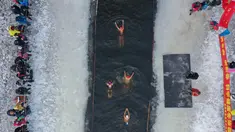 Foto udara pada 25 Januari 2022 menunjukkan penggemar renang musim dingin berenang di danau yang sebagian beku di Shenyang, di provinsi Liaoning, China. Penduduk lokal banyak menggemari kebiasaan berenang di musim dingin di mana banyak sungai dan danau-danau mulai membeku. (STR/AFP)