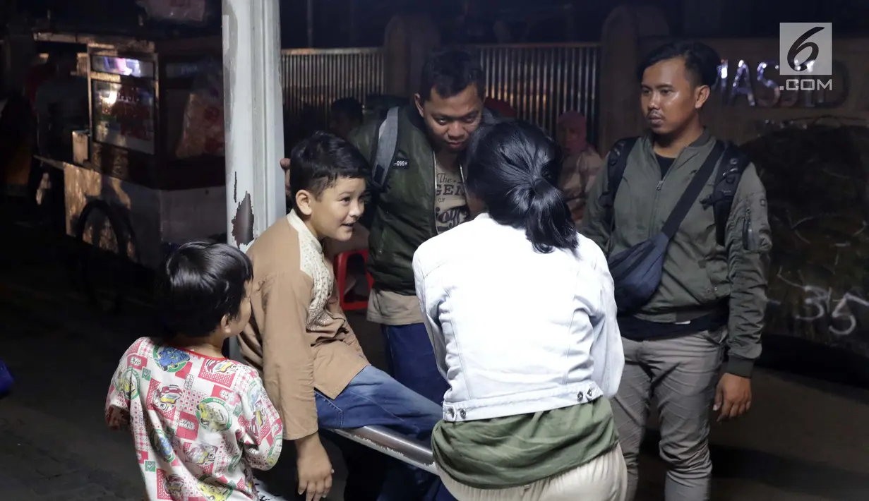 Seorang anak pencari suaka berbincang dengan pewarta di trotoar depan Masjid Ar-Rayan, Jalan Kebon Sirih, Jakarta, Jumat (5/7/2019). Para pencari suaka ini membangun tenda-tenda dan meminta kepastian perlindungan dari UNHCR . (Liputan6.com/Helmi Fithriansyah