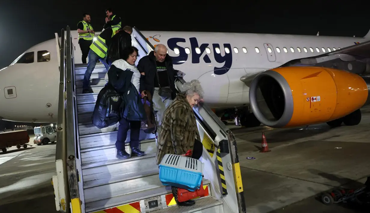 Pengungsi Yahudi Ukraina dan imigran baru yang melarikan diri dari perang di negara mereka turun dari pesawat setibanya di Bandara Ben Gurion, Tel Aviv, Israel, 22 Desember 2022. Sebanyak 100 orang Yahudi Ukraina tiba di Israel, termasuk beberapa penumpang yang terbaring di tempat tidur dan dalam kondisi sakit. (GIL COHEN-MAGEN/AFP)