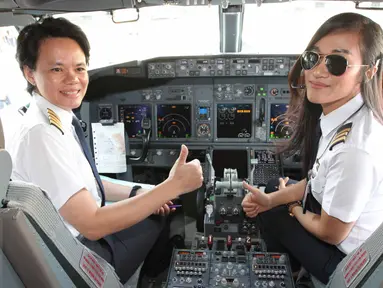 Kapten pilot Garuda Indonesia Ida Fiqria (kiri) dan kopilot Sari Ardisa bersiap menerbangkan pesawat di bandara Minangkabau, Padang, Sumbar, Jumat (21/4). Peringati hari Kartini 2017, pesawat seluruhnya diawaki oleh perempuan. (Liputan6.com/Angga Yunair)