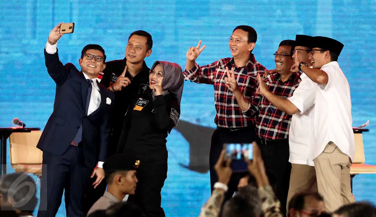 Pembawa acara Alfito Deannova Ginting berfoto bersama para paslon Pilgub DKI usai Debat Cagub DKI Jakarta putaran ketiga di Hotel Bidakara, Jakarta, Jumat (10/2).(Liputan6.com/Faizal Fanani)