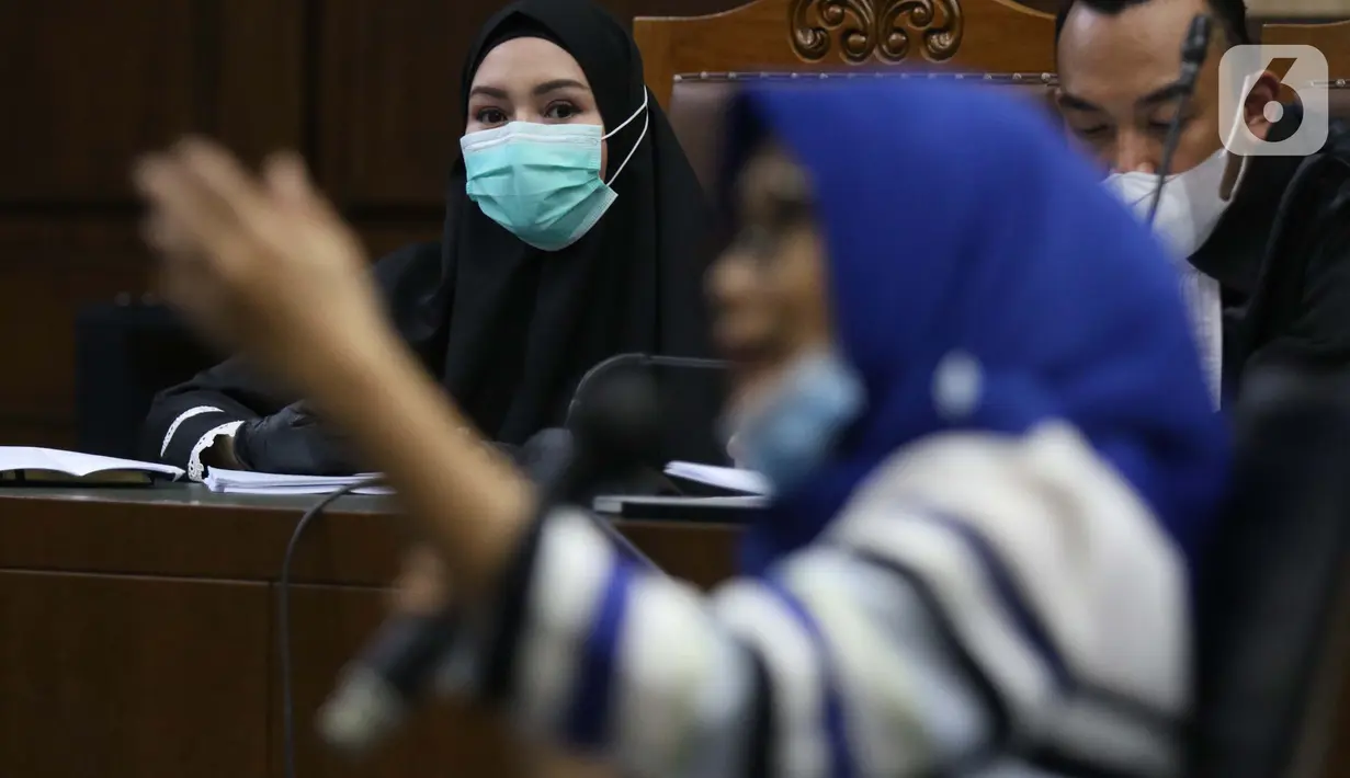 Terdakwa dugaan suap dan tindak pidana pencucian uang terkait pengurusan fatwa Mahkamah Agung, Pinangki Sirna Malasari menyimak kesaksian mantan kuasa hukum Djoko S Tjandra Anita Kolopaking saat sidang lanjutan di Pengadilan Tipikor Jakarta, Rabu (25/11/2020). (Liputan6.com/Helmi Fithriansyah)