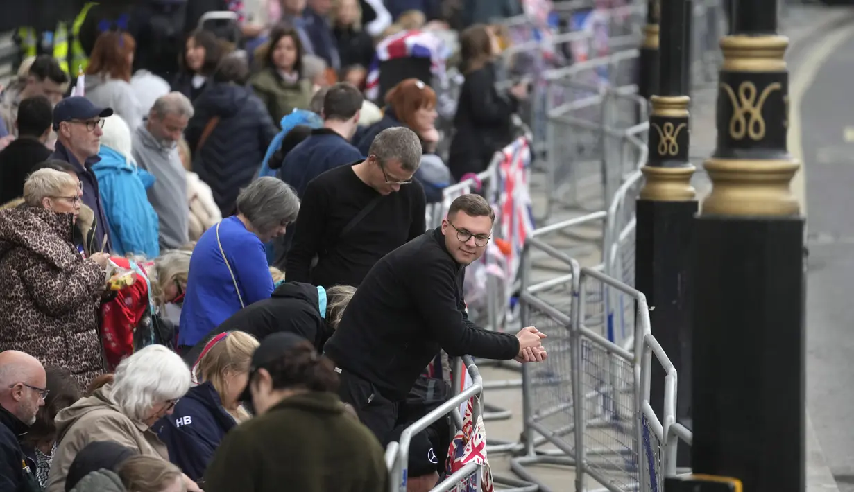 Massa berkumpul di Whitehall menjelang upacara penobatan Raja Charles III  di London, Sabtu (6/5/2023).  (AP Photo/Mosa'ab Elshamy)