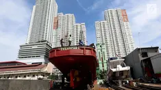 Pekerja memperbaiki kapal nelayan yang rusak di kawasan Muara Angke, Jakarta Utara, Selasa (7/11). Perbaikan ini rutin dilakukan untuk memperkokoh bagian-bagian kapal agar bisa maksimal saat berlayar untuk mencari ikan di laut. (Liputan6.com/Johan Tallo)