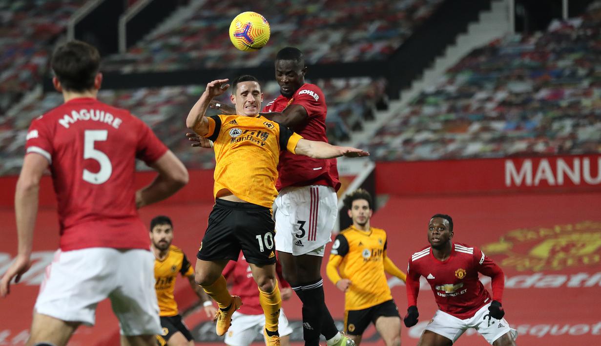 Gelandang Wolverhampton Wanderers, Daniel Podence (kiri) berduel udara dengan bek Manchester United, Eric Bailly dalam laga lanjutan Liga Inggris 2020/21 pekan ke-16 di Old Trafford, Selasa (29/12/2020). Wolverhampton kalah 0-1 dari Manchester United. (AFP/Martin Rickett/Pool)