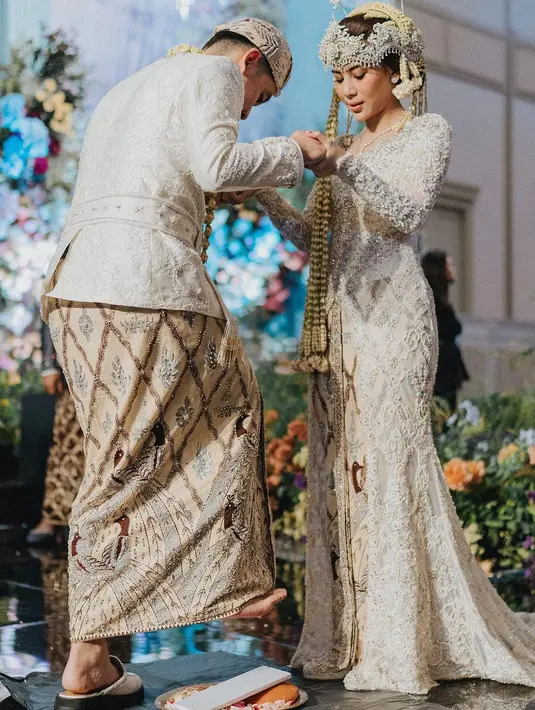 Adinda Thomas memilih kebaya dress berpayet warna putih yang dipadukan dengan batik yang dihiasi oleh payet di wiru saat hari pernikahannya. [@adindathomas]