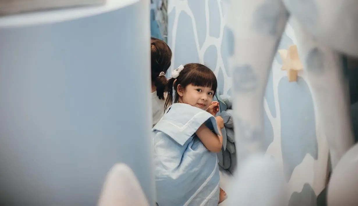 Di acara ulang tahun adiknya, Natusha tampil dengan dress panjang berwarna biru muda dengan detail cape dan pita putih kecil. Foto: Instagram.