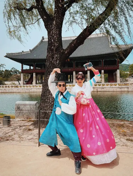Liburan ke Korea Selatan, tentu akan kurang rasanya apabila belum menjalani pemotretan mengenakan hanbok. Sebuah busana khas Korea Selatan yang menjadi daya tarik wisata di Negeri Gingseng tersebut. Pasangan ini pun berpose dengan gaya kocak yang menuai gelak tawa netizen. (Liputan6.com/IG/@winkywiryawan912)