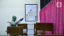 Petugas menyemprotkan disinfektan di ruang kelas SDN 08 Duri Pulo, Jakarta Pusat, Jumat (28/1/2022). Penyebaran COVID-19 di sejumlah kawasan pendidikan di DKI Jakarta kembali bertambah, pihak sekolah bekerja sama dengan PMI untuk mengantisipasi penyebaran COVID-19. (Liputan6.com/Faizal Fanani)