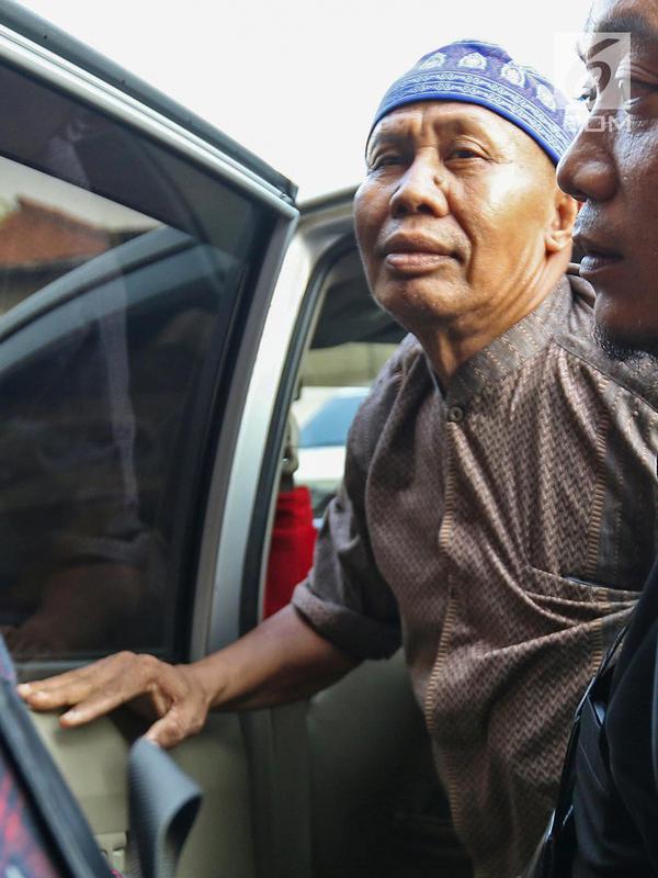 Abah Grandong pemakan kucing didampingi kerabat tiba di Polres Jakarta Pusat, Kamis (1/8/2019). Abah Grandong yang berprofesi sebagai centeng di lahan sengketa kawasan Kemayoran tiba mengenakan peci serta baju koko berwarna cokelat. (Liputan6.com/Herman Zakharia)