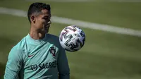 Pemain depan Portugal, Cristiano Ronaldo menghadiri sesi latihan dalam persiapan untuk Euro 2020 di kamp pelatihan "Cidade do Futebol" di Oeiras, Senin (7/6/2021). Bintang Juventus itu telah mulai bermain untuk Timnas Portugal sejak tahun 2003 lalu. (PATRICIA DE MELO MOREIRA/AFP)