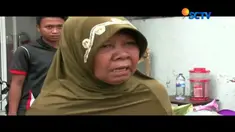 Salah seorang ibu mempertahankan gerobak dagangnnya agar tidak dibawa oleh petugas.  