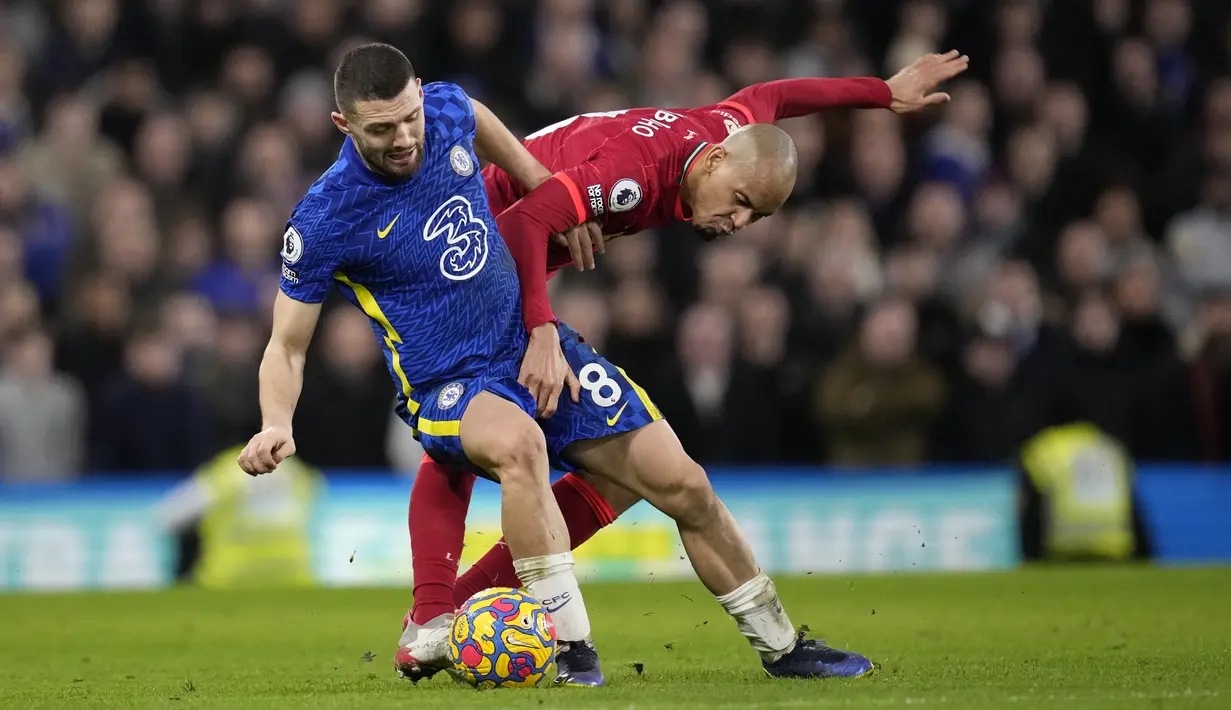 Gelandang Chelsea Mateo Kovacic berebut bola dengan gelandang Liverpool Fabinho pada pekan ke-21 Liga Inggris di Stamford Bridge, London, Minggu (2/1/2022) malam WIB. Duel Chelsea vs Liverpool berakhir imbang dengan skor akhir 2-2. (AP Photo/Matt Dunham)