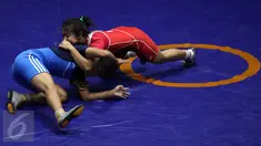Pegulat putri Kaltim, Inadrah (kostum merah) melakukan teknik kuncian saat laga final gaya bebas kelas 53 kg putri pada PON XIX melawan pegulat putri Sumbar Mardiatul di Arena Saparua Sport Park, Bandung, Sabtu (24/9). (Liputan6.com/Helmi Fithriansyah)