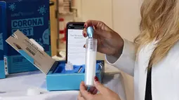 Seorang staf mendemonstrasikan cara menggunakan alat tes COVID-19 di sebuah gerai BIPA di Wina, Austria, Selasa (21/7/2020). Orang-orang cukup mengumpulkan sampel dengan cara berkumur. (Xinhua/Georges Schneider)
