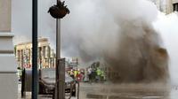 Sebuah pipa uap meledak menyebabkan gumpalan besar asap putih mengepul di Distrik Flatiron, Manhattan, Kamis (19/7). Ledakan itu mendorong pihak berwenang untuk mengevakuasi 28 bangunan sebagai tindakan pencegahan. (AP Photo/Richard Drew)