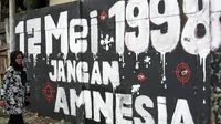 Salah satu keluarga korban tragedi Mei Tahun 1998 Ruyati berjalan di depan mural pelanggaran HAM ketika peresmian mural Prasasti Tragedi Trisakti dan Mei 1998 di kawasan Jalan Pemuda, Jakarta Timur. (ANTARA FOTO/Reno Esnir)