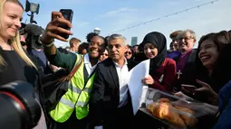 Walikota London terpilih Sadiq Khan berselfie dengan pendukung saat tiba untuk hari pertamanya bekerja di Balai Kota di London, Inggris (9/5). Pria 45 tahun ini merupakan Wali Kota Muslim Pertama di London dan kedua di Eropa. (REUTERS / Hannah McKay)
