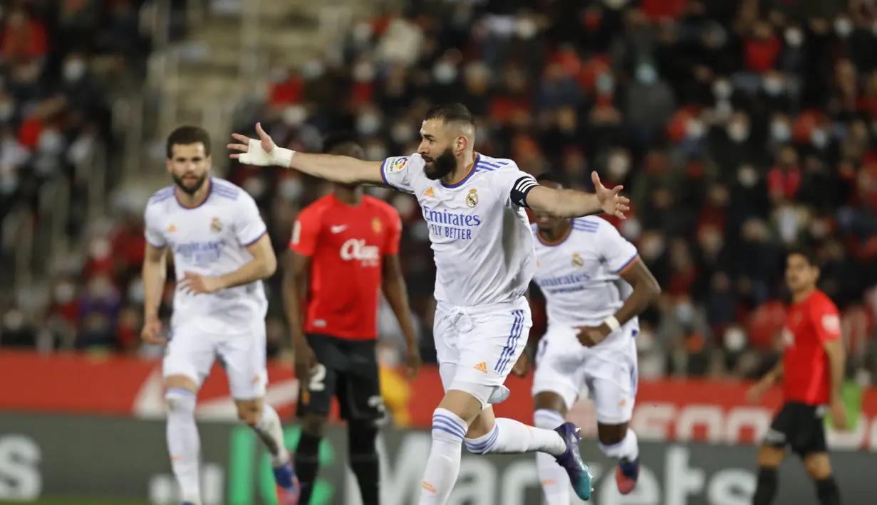 Penyerang Real Madrid, Karim Benzema berselebrasi usai mencetak gol ke gawang Mallorca pada pertandingan lanjutan La Liga Spanyol di Palma de Mallorca, Spanyol, Selasa (15/3/2022). Madrid menang telak atas Mallorca 3-0. (AP Photo/Francisco Ubilla)