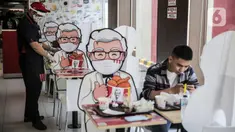 Pelayan merapikan banner bergambar karakter di KFC Salemba, Jakarta, Selasa (23/6/2020). Banner bergambar tersebut berguna untuk pembatas bagi pengunjung yang makan di tempat saat fase kenormalan baru. (Liputan6.com/Faizal Fanani)