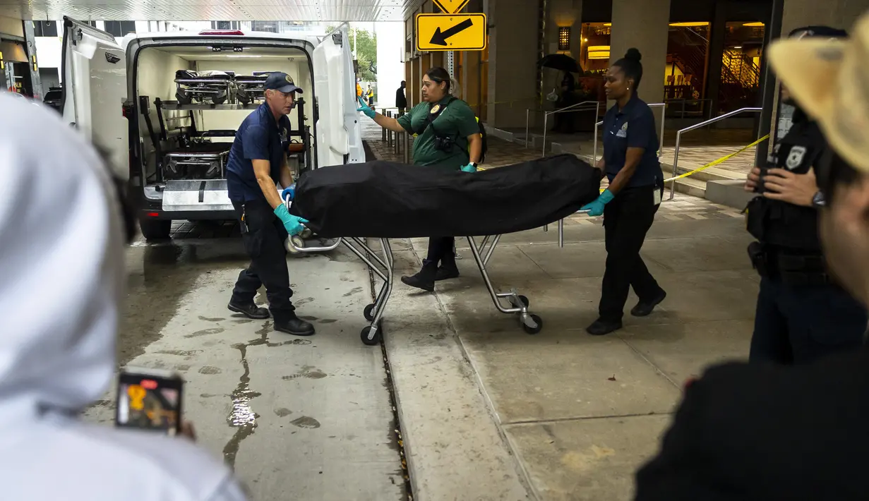 Fans Rapper Takeoff Migos menonton dan merekam saat pemeriksa medis mengeluarkan jenazah dari lokasi penembakan di 1201 San Jacinto, di Houston, Texas, Selasa (1/11/2022). Tiba-tiba terjadi pertengkaran. Dan saat itulah orang tak dikenal melepas tembakan dan mengenai Takeoff.  (Annie Mulligan/Houston Chronicle via AP)