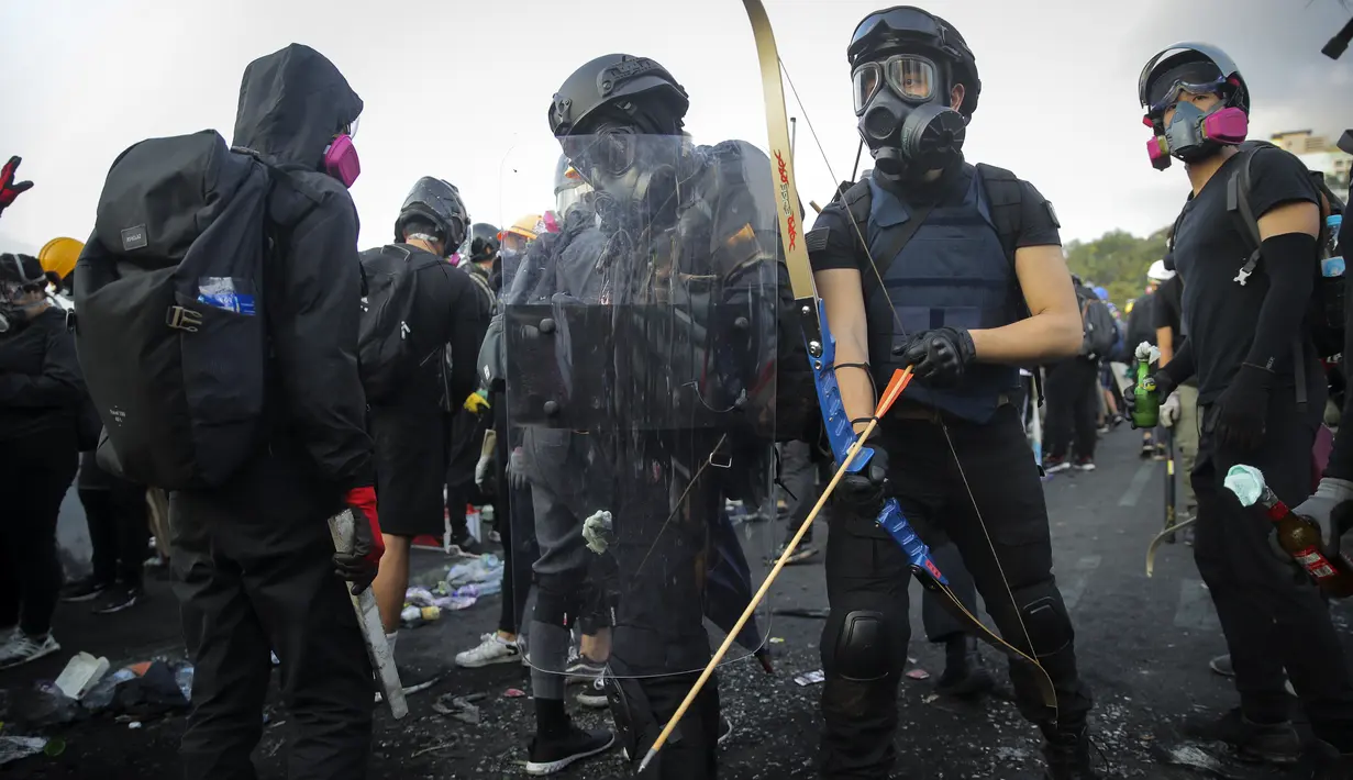 Seorang mahasiswa menggunakan panahan saat demonstrasi di Hong Kong (13/11/2019). Gerakan antipemerintah Hong Kong yang telah berlangsung selama lima bulan bertindak semakin keras. (AP Photo/Kin Cheung)