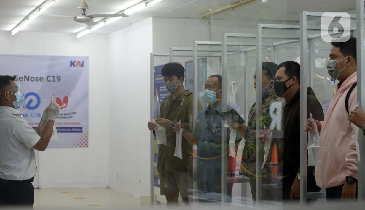 Petugas mengajari calon penumpang untuk tes COVID-19 dengan GeNose C19 di Stasiun Pasar Senen, Jakarta, Selasa (23/2/2021). PT KAI memberikan pelayanan tes COVID-19 dengan GeNose C19 bagi calon penumpang kereta jarak jauh untuk memutus rantai penyebaran virus corona. (merdeka.com/Imam Buhori)