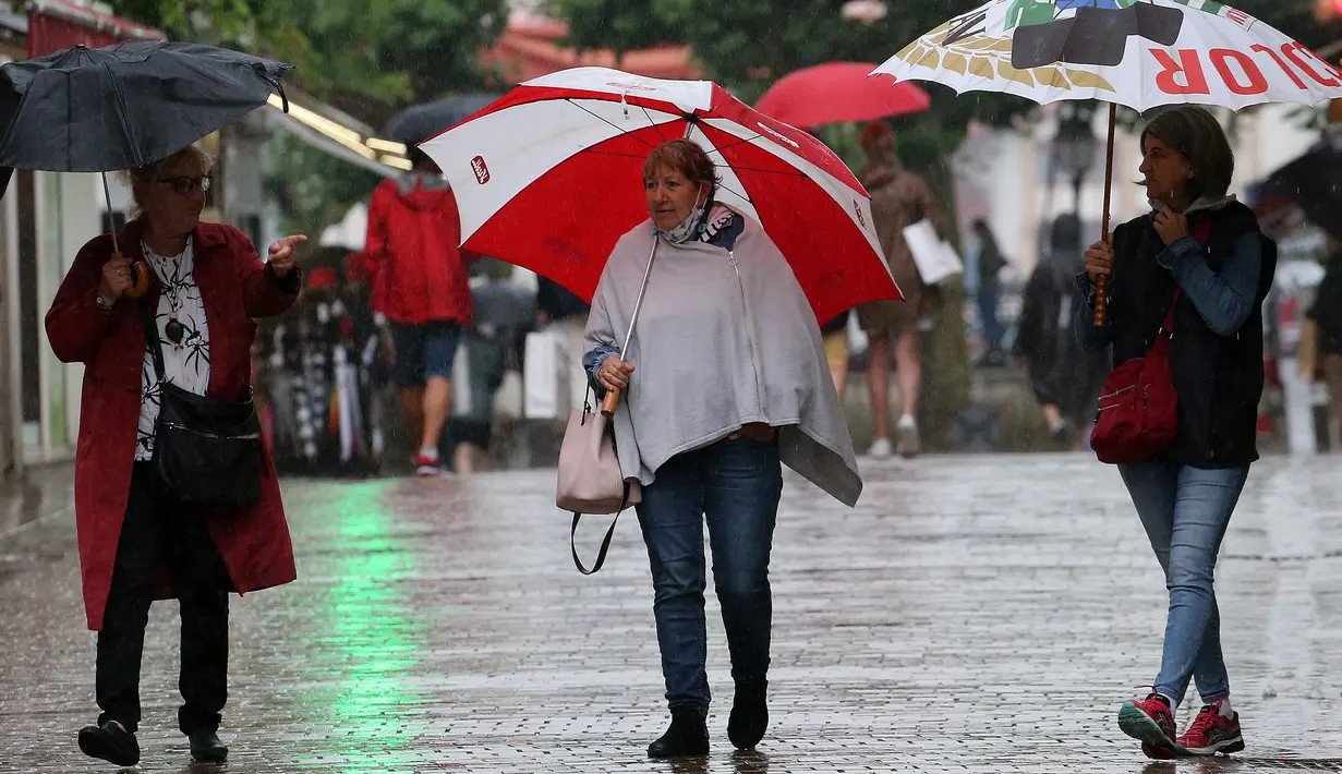 Orang-orang tanpa masker melintasi jalan di Saint Jean de Luz, Prancis, Kamis (17/6/2021). Prancis mengumumkan melonggarkan aturan pembatasan COVID-19, mencabut aturan penggunaan masker di luar ruangan dan menghentikan jam malam mulai pekan ini setelah delapan bulan terakhir. (AP Photo/Bob Edme)