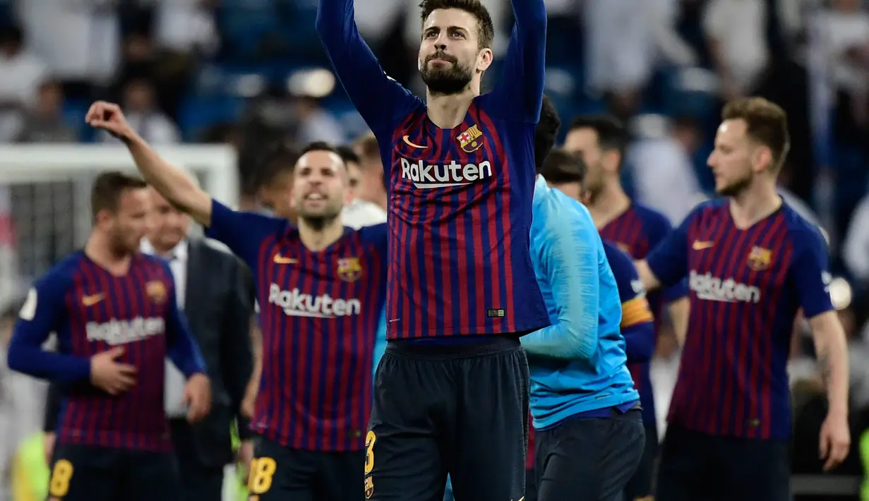 Bek Barcelona, Gerard Pique dan timnya berselebrasi setelah menang atas Real Madrid pada laga leg kedua semifinal Copa del Rey di Stadion Santiago Bernabeu, Rabu (27/2). Barcelona merebut tiket final Copa del Rey usai menang 3-0. (JAVIER SORIANO / AFP)