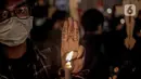 Seorang aktivis mengacungkan tiga jari dalam aksi solidaritas untuk rakyat Myanmar di depan Kantor ASEAN, Jakarta, Jumat (12/3/2021).  Aktivis mengutuk semua aktivitas junta militer yang berubah menjadi tindakan kekerasan di Myanmar. (Liputan6.com/Faizal Fanani)