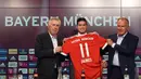 Pemain baru Bayern Munchen, James Rodriguez, memegang jersey nomor 11 saat perkenalan dirinya di Munchen, Rabu (12/7/2017). (AFP/Christof Stache)