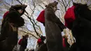 Orang-orang yang mengenakan kostum bulu beruang mengikuti parade di Comanesti, Romania, Jumat, 30 Desember 2022. Dentuman genderang dimulai pagi-pagi sekali menandakan kedatangan ratusan orang yang turun ke kota Comanesti yang mengenakan kostum terbuat dari bulu beruang dengan kepala yang masih menempel. (AP Photo/Vadim Ghirda)
