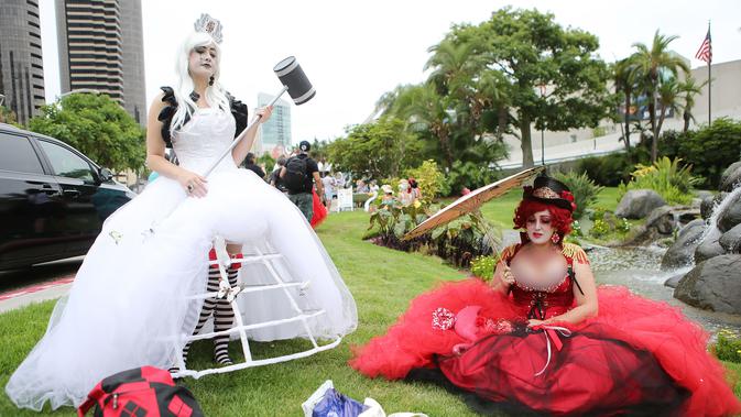 Cosplay berpakaian White Queen dan Queen of Hearts berpose di luar San Diego Comic-Con, San Diego, California, Amerika Serikat, Jumat (20/7). (Mario Tama/Getty Images/AFP)