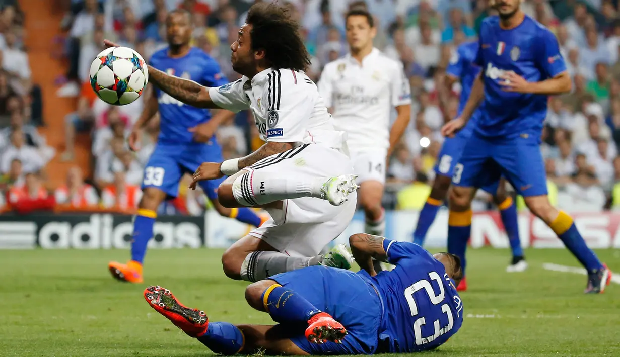 Bek Real Madrid, Marcelo (atas) berusaha melewati gelandang Juventus, Arturo Vidal saat leg kedua semifinal Liga Champions di Stadion Santiago Bernabeu, Kamis (14/5/2015). Real Madrid bermain imbang 1-1 atas Juventus. (Reuters/Paul Hanna)