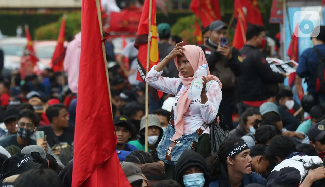 Pedagang asongan berjualan di tengah-tengah aksi unjuk rasa di kawasan Patung Kuda, Jakarta, Selasa (10/11/2020). Sejumlah pedagang mencoba peruntungan saat massa gabungan dari berbagai organisasi buruh dan mahasiswa berunjuk rasa menolak Omnibus Law UU Cipta Kerja. (Liputan6.com/Helmi Fithriansyah)