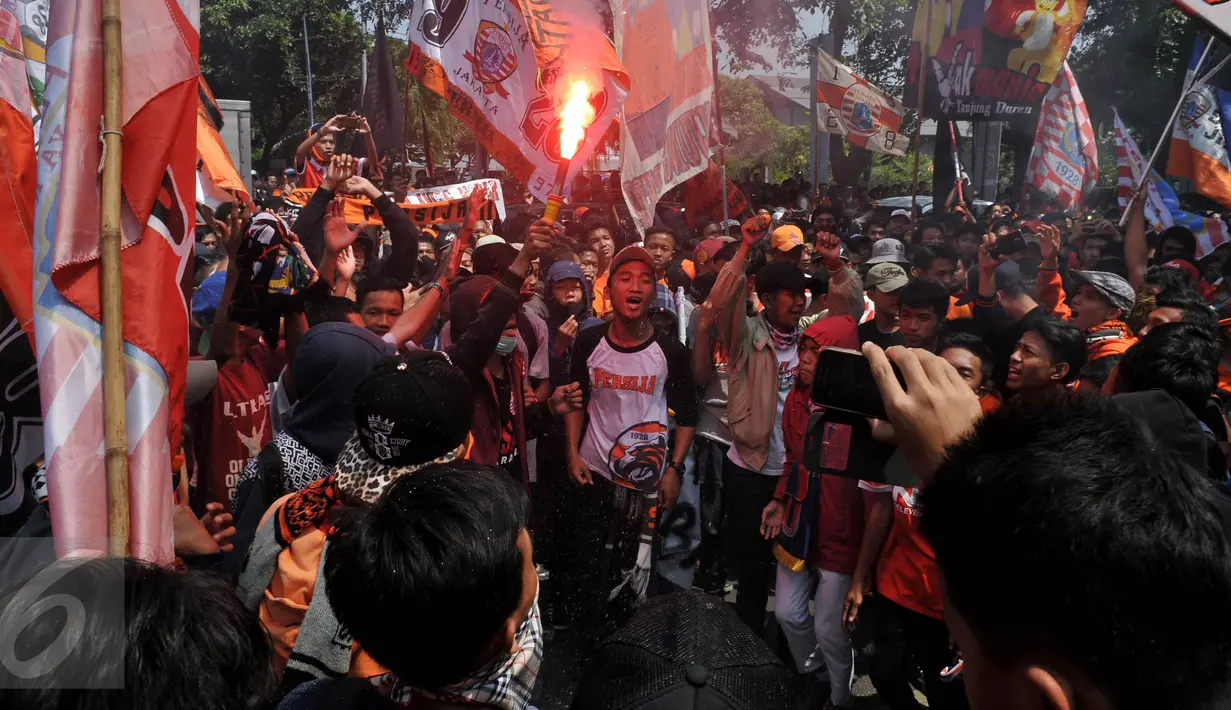 Ratusan Jakmania melakukan aksi unjukrasa dengan menyalakan flare depan Kantor Kementerian Pemuda dan Olahraga, Jakarta, Selasa (11/8/2015). mereka meminta Surat Keputusan (SK) Menpora terkait pembekuan PSSI dicabut.(Liputan6.com/Johan Tallo)