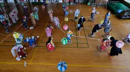 Tsukimi Ayano memeriksa boneka-bonekanya yang dipajang di sebuah sekolah dasar di desa kecil Nagoro, Jepang, 16 Maret 2019. Tsukimi Ayano mulai meletakkan boneka-boneka di Desa Nagoro karena desa kecil teresebut semakin sepi ditinggal penduduknya. (KAZUHIRO NOGI/AFP)