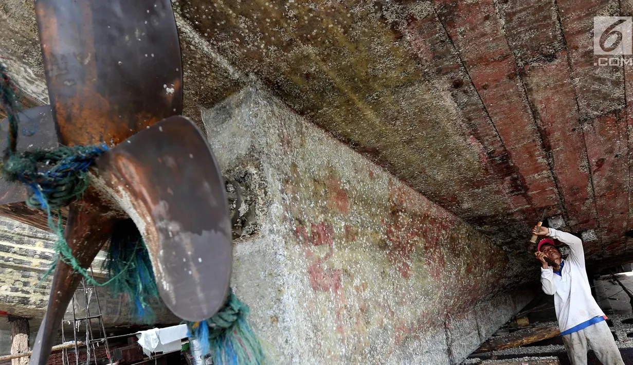 Pekerja merenovasi bagian kapal yang rusak di kawasan Muara Angke, Jakarta Utara, Selasa (7/11). Perbaikan ini rutin dilakukan untuk memperkokoh bagian-bagian kapal agar bisa maksimal saat berlayar untuk mencari ikan di laut. (Liputan6.com/Johan Tallo)