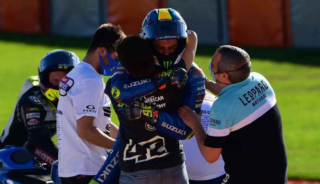 Pembalap Suzuki Ecstar, Joan Mir (tengah) merayakan bersama timnya setelah memenangkan kejuaraan dunia MotoGP setelah Grand Prix Valencia di sirkuit Ricardo Tormo di Valencia  (15/11/2020). (AFP/Lluis Gen)