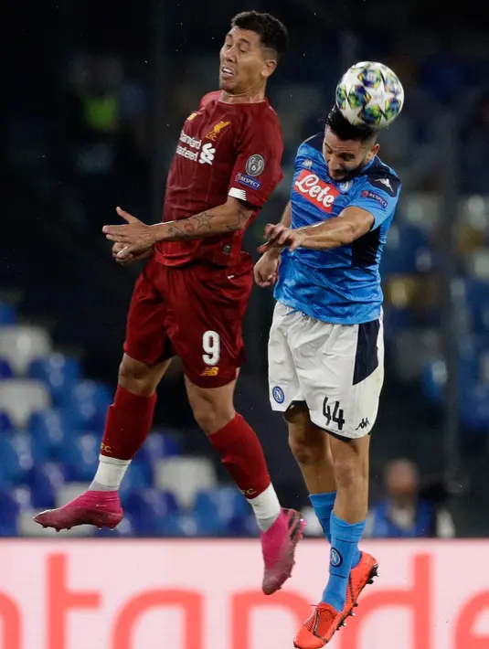 Striker Liverpool, Roberto Firmino, berebut bola dengan pemain Napoli, Kostas Manolas pada matchday pertama Grup E Liga Champions di Stadion San Paolo, Selasa (17/9/2019). Napoli menundukkan Liverpool 2-0. (AP/Gregorio Borgia)
