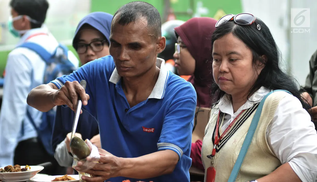 Pembeli mengemas makanan yang dibeli warga untuk berbuka puasa atau takjil di kawasan Bendungan Hilir, Jakarta, Kamis (17/5). (Merdeka.com/Iqbal Nugroho)