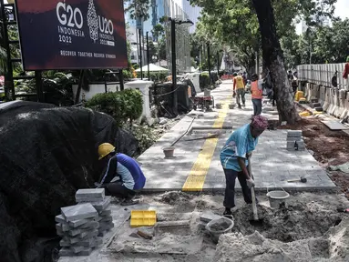 Pekerja menyelesaikan proyek revitalisasi trotoar di Jalan Medan Merdeka Selatan, Jakarta Pusat, Selasa (22/11/2022). Pemprov DKI Jakarta mengalokasikan anggaran sebesar Rp 171 miliar dalam Rancangan Anggaran Pendapatan dan Belanja Daerah (RAPBD) DKI Jakarta 2023 untuk revitalisasi trotoar di Ibu Kota. (merdeka.com/Iqbal S. Nugroho)