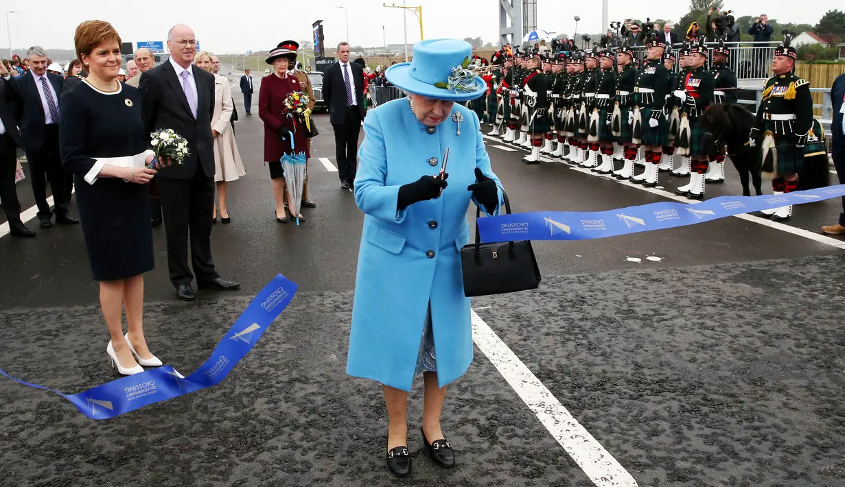 Ratu Inggris Elizabeth II memotong pita dalam peresmian jembatan Queensferry di Skotlandia, Minggu (4/9). Jembatan Queensferry resmi dibuka untuk menghubungkan antar ibu kota Edinburgh dengan bagian utara Skotlandia. (Andrew Milligan/PA via AP)