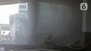 Petugas berusaha memadamkan kebakaran di Gedung Cyber 1, Jakarta, Kamis (2/12/2021). Suku Dinas Pemadam Kebakaran DKI Jakarta menurunkan 22 unit mobil pemadam kebakaran. (Liputan6.com/Herman Zakharia)